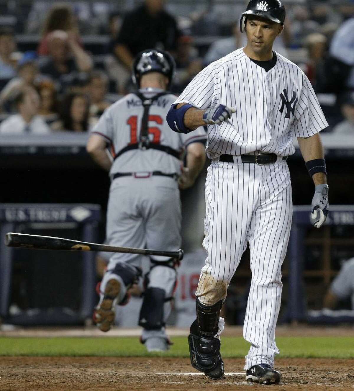 ASSOCIATED PRESS New York Yankees Raul Ibanez tosses his bat after a seventh-inning strikeout as Atlanta Braves catcher Brian McCann returns to the dugout during Tuesday night's game at Yankee Stadium in New York. The Yankees lost 4-3. Ibanez stranded two runners on base on his strikeout.