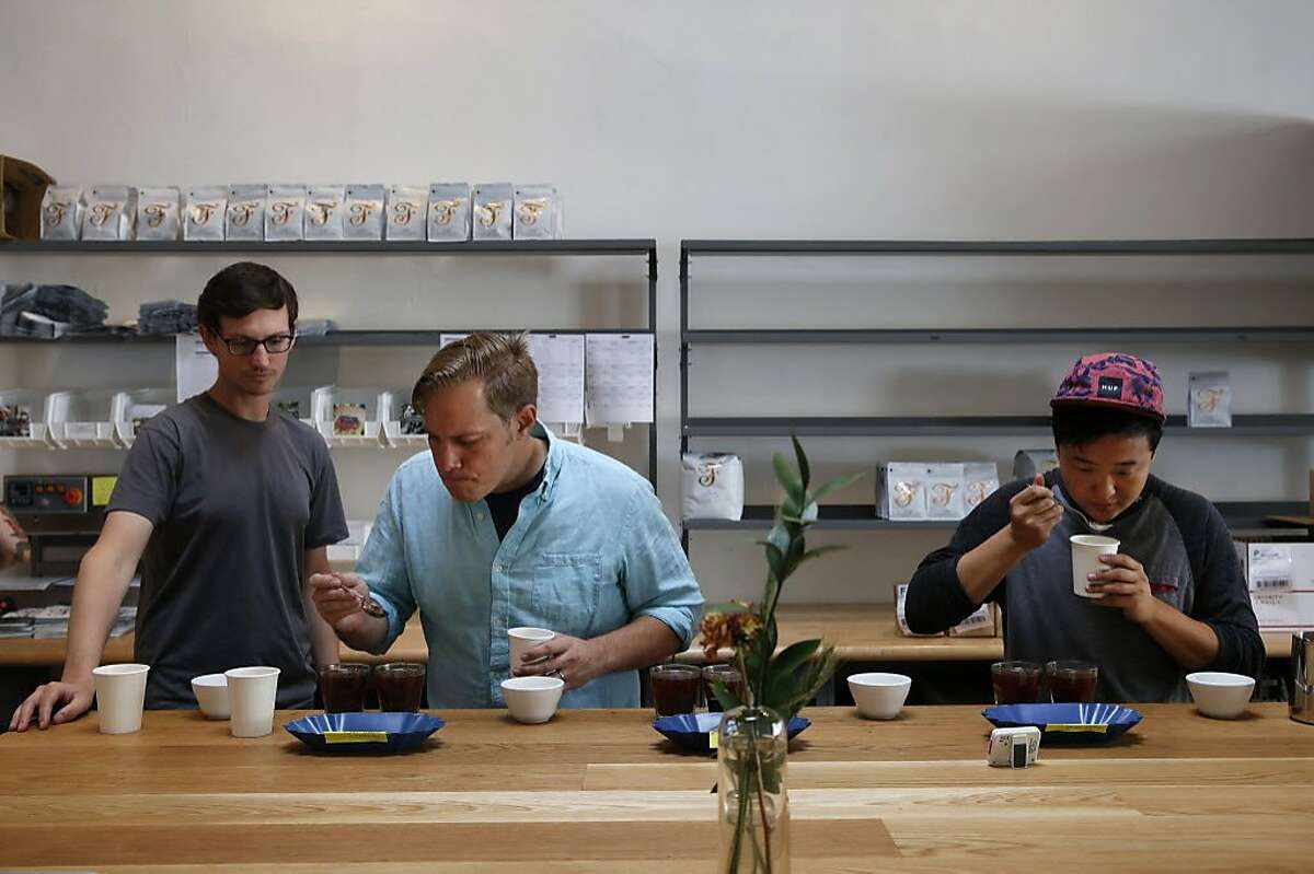Owner Kevin Bohlin, center, tastes coffee samples with John Felder, left, and Joshua Lee at Saint Frank Coffee's roastery on Mission Street in San Francisco.