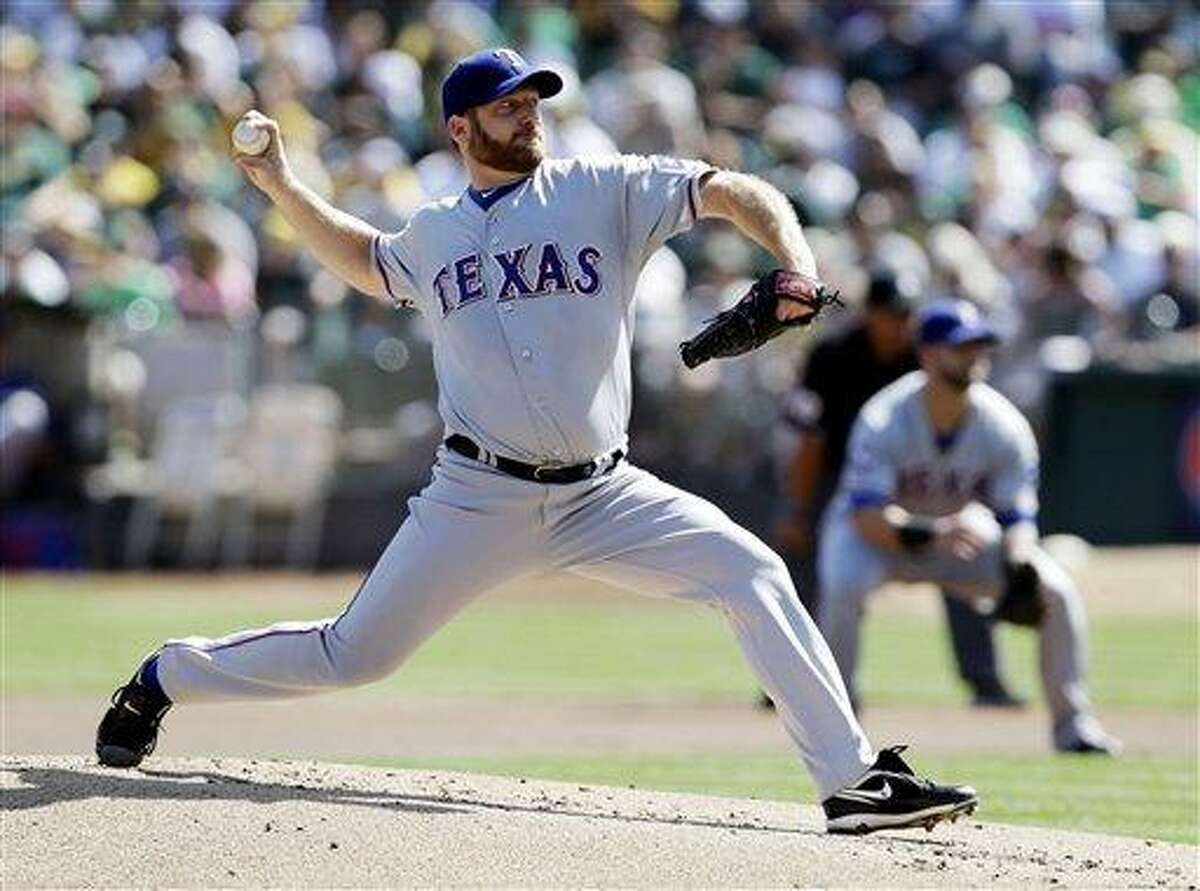FILE - This Oct. 3, 2012 file photo shows Texas Rangers starting pitcher Ryan Dempster throwing against the Oakland Athletics during the first inning of a baseball game in Oakland, Calif. Two people familiar with the negotiations say the Boston Red Sox have agreed to a $26.5 million, two-year contract with Dempster. The people spoke on condition of anonymity Thursday, Dec. 13, 2012, because the agreement is pending a physical. (AP Photo/Marcio Jose Sanchez, File)