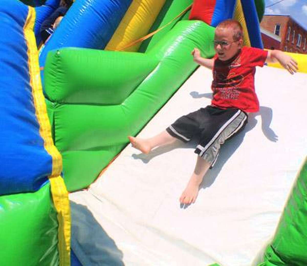 Dispatch Staff Photo by JOHN HAEGER twitter.com/oneidaphoto Dokata Lighthaul 6, of Oneida slides down one of the bounce houses during the annual Rock the Block held by Church on the Rock on Saturday, June 16 , 2012 in Oneida.