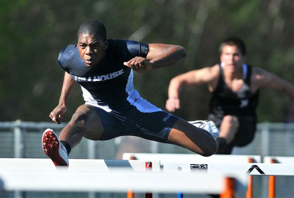 Hillhouse's Danny Lewis on his way to a first-place finish in the 100-meter hurdles in Tuesday's SCC track meet at Shelton. Photo- Peter Casolino/New Haven Register.