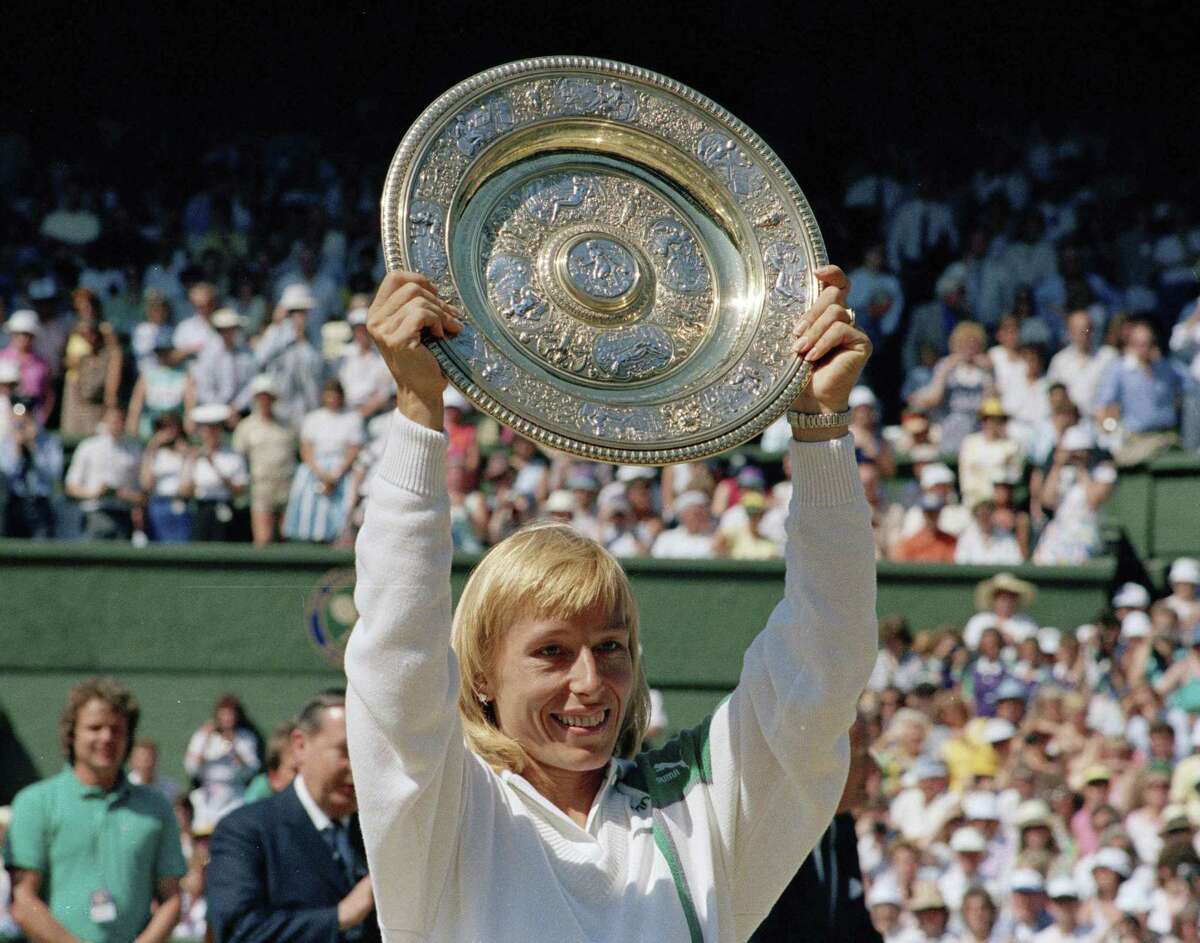 In this July 4, 1987, file photo, Martina Navratilova holds up her trophy after winning the women’s singles championship on the Centre Court at Wimbledon, England.