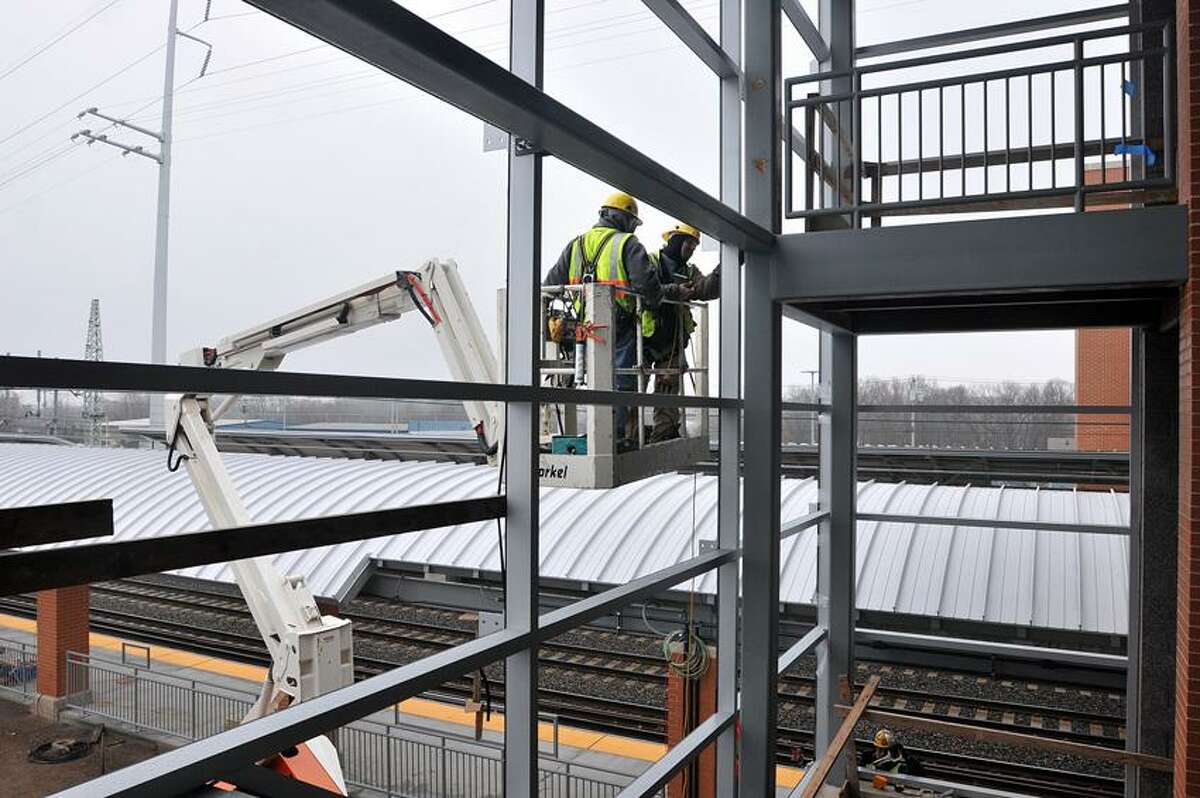 Glass installers work at the new West Haven Train Station. Peter Casolino