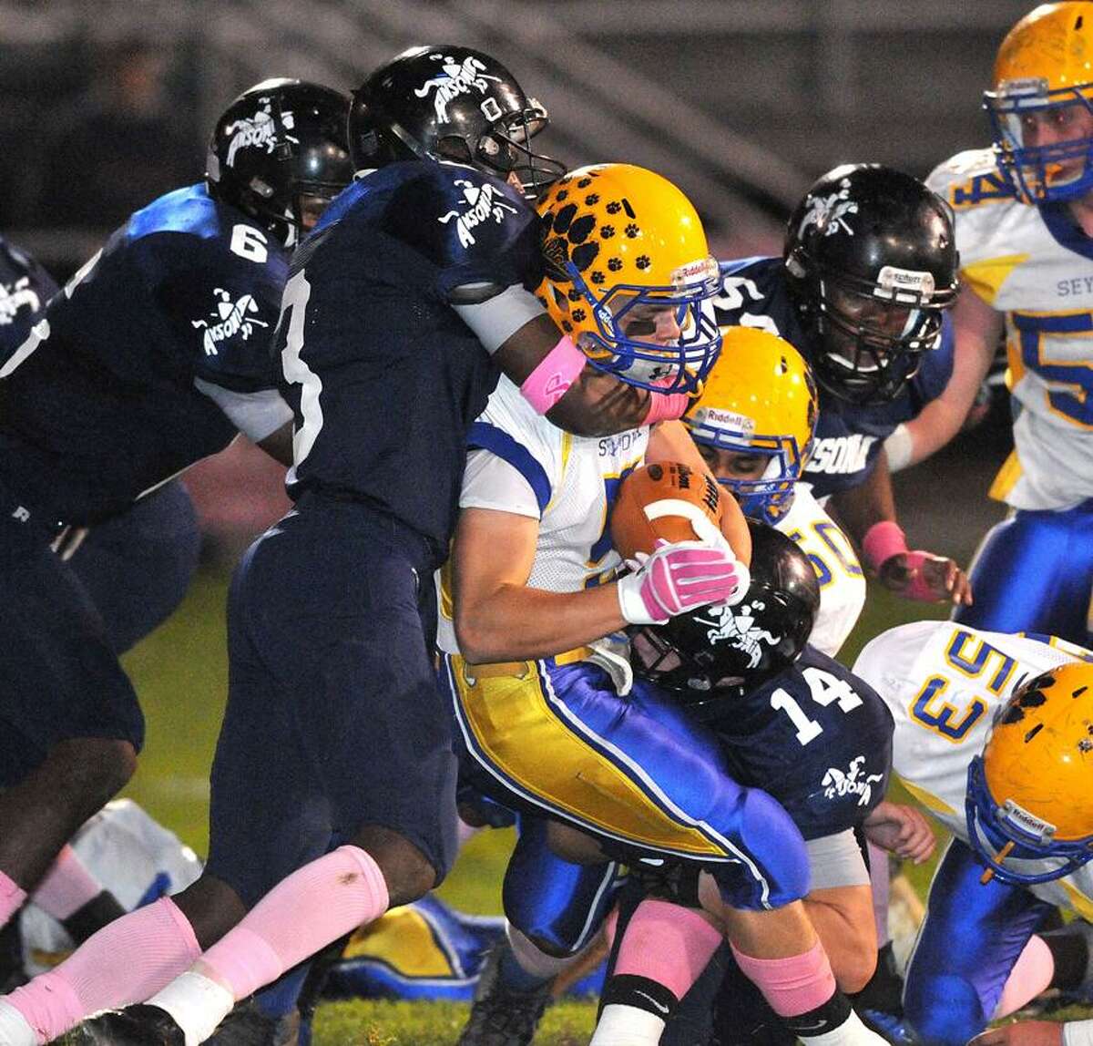 Ansonia-- The Ansonia defense swarms Seymour's Joseph Salemme during the second quarter. Making the tackle is Saiheed Sanders, left, and Joe Price, bottom (#14). Photo Peter Casolino/New Haven Register