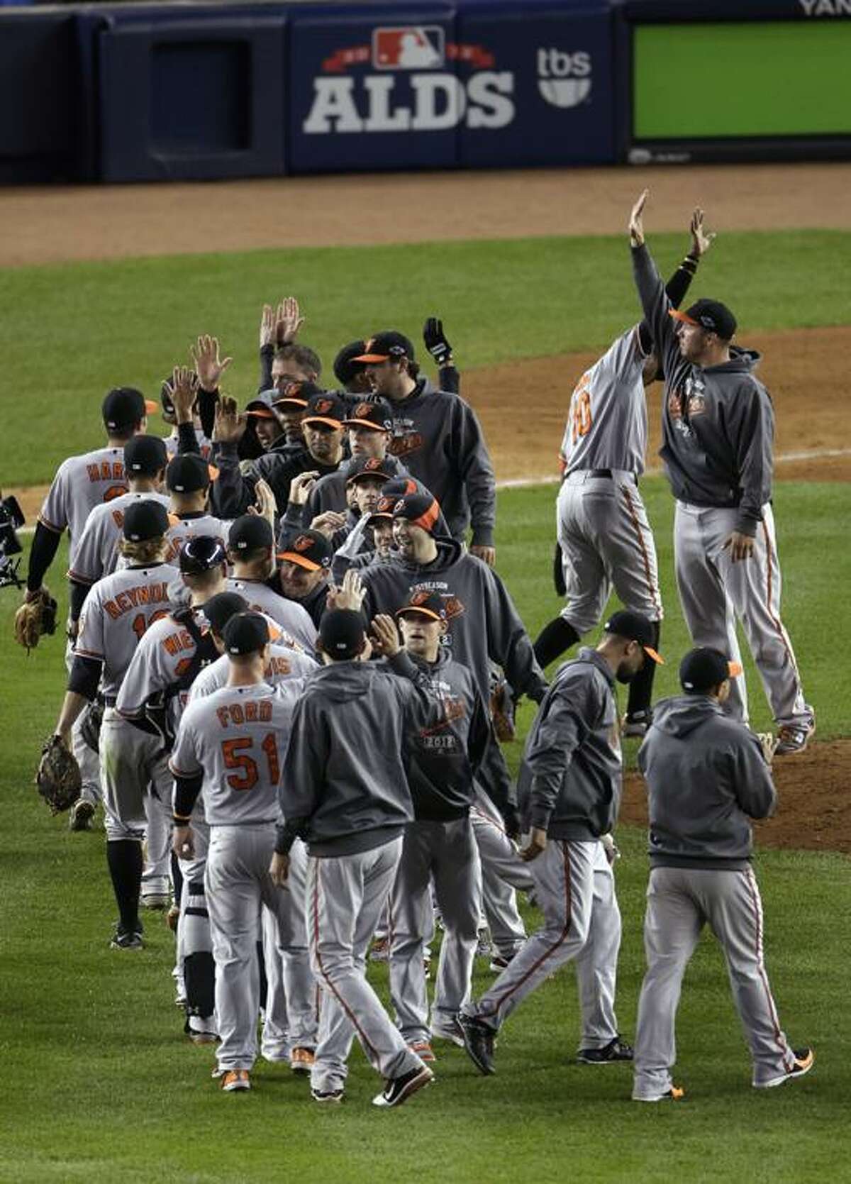 The Baltimore Orioles celebrate after beating the New York Yankees 2-1 in 13 innings in Game 4 of the American League division baseball series Thursday, Oct. 11, 2012, in New York. (AP Photo/Peter Morgan)
