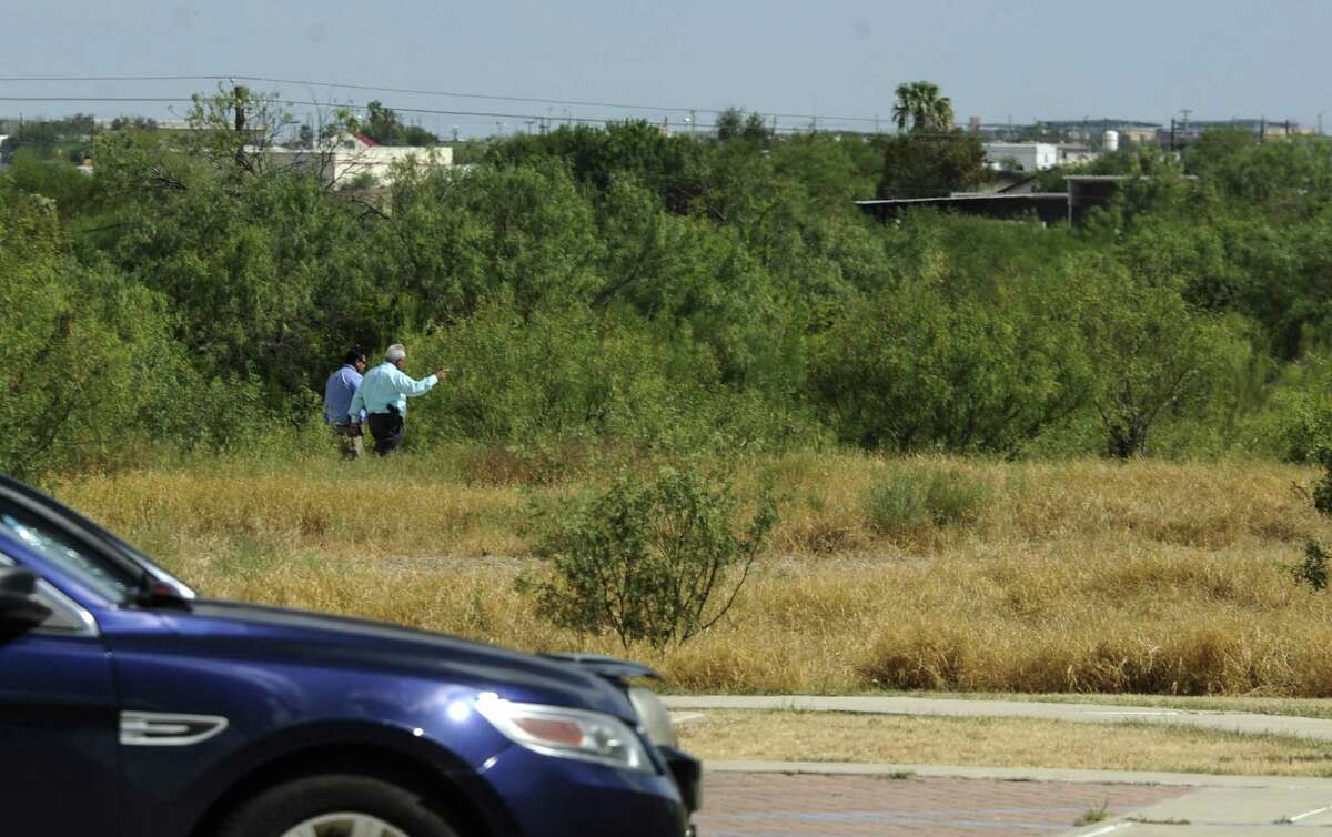 Investigators approach the area behind Haynes Recreation Center on Tuesday, July 27, 2017 where the body of a young woman was discovered in the brush next to the running trails.