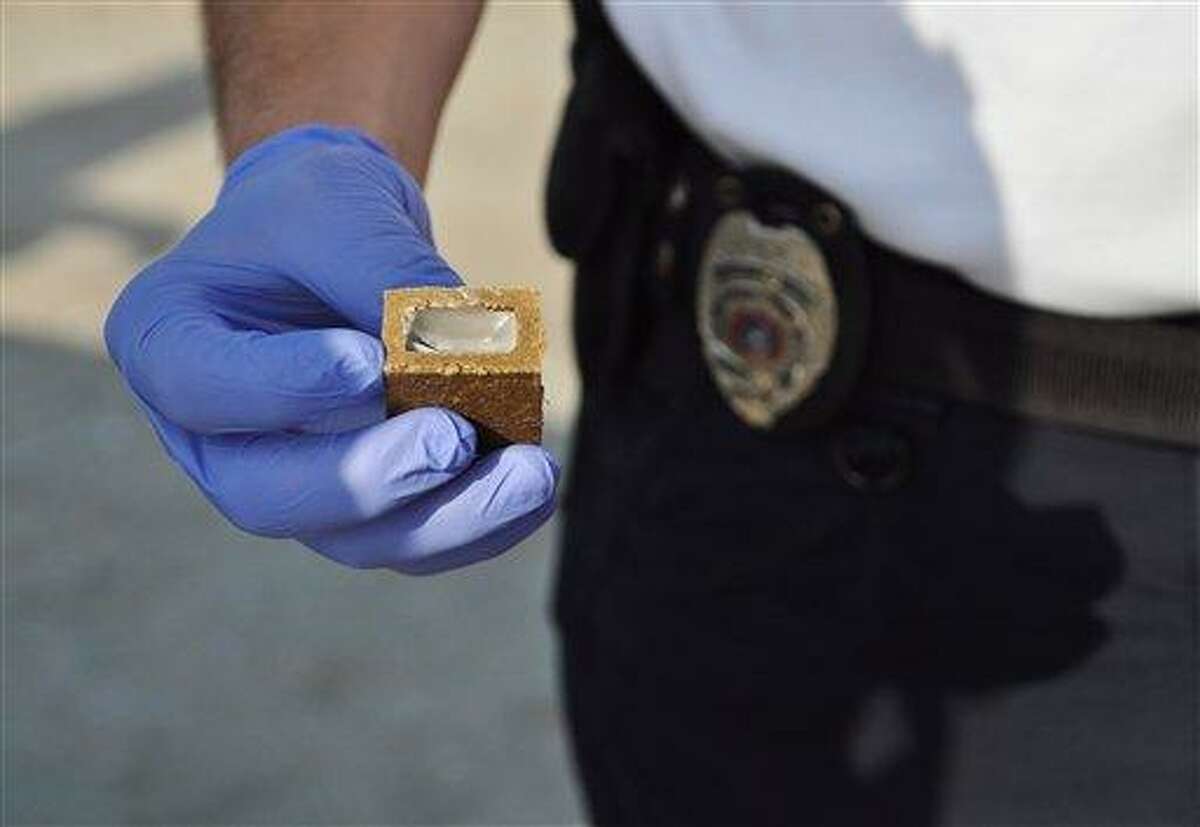 An animal control officer from Texas holds up a piece of vaccine bait, which health officials hope will curb rabies outbreaks nationwide. A vaccine capsule is hidden within a small chunk of white wax, which is in turn surrounded by a hard cube made of fish meal. The pungent smell of the fishmeal attracts animals, which bite into the cubes, breaking open the vaccine capsules, and thus becoming innoculated. Associated Press