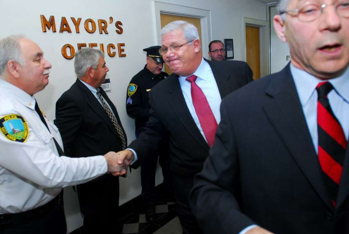 East Haven Police Chief Leonard Gallo (center) shakes hands with Inspector Gaetano Nappi (left) after East Haven Mayor Joe Maturo, Jr., (right) reinstated Gallo was to his former position at a press conference at East Haven Town Hall on 11/29/2011.Photo by Arnold Gold/New Haven Register AG0431D