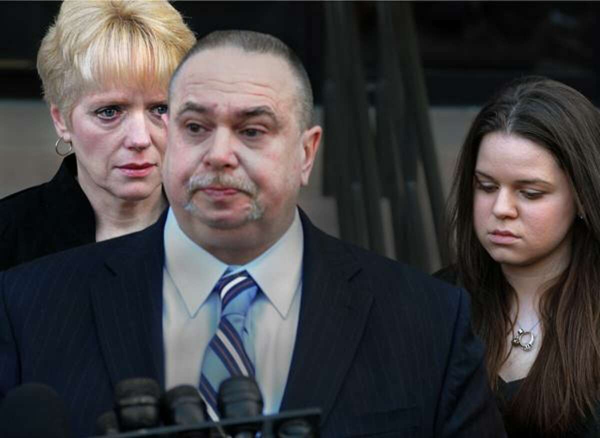 Raymond Clark III's father, Raymond Clark II, center, reads a statement to the press after leaving court. Clark's mother, Diane Clark, is at left, and his fiancee, Jennifer Hromadka, is at right. (Melanie Stengel/New Haven Register)