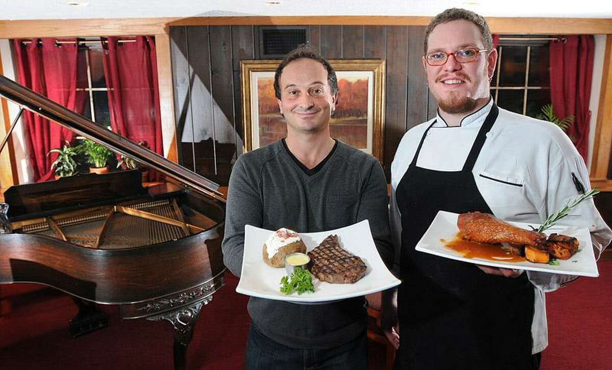 Claudio Sanfrancesco, co-owner, and Executive Chef Glen Rosengrant are excited about the changes at Chuck's Orange Avenue Steak House in West Haven, including a new menu and a piano in the dining area. Sanfrancesco is holding a Chuck's staple, a Delmonico steak, and Rosengrant is holding a smoked turkey drumstick with sweet potatoes and a roasted garlic demi-glace, which is a new addition to the menu. Peter Casolino/Register