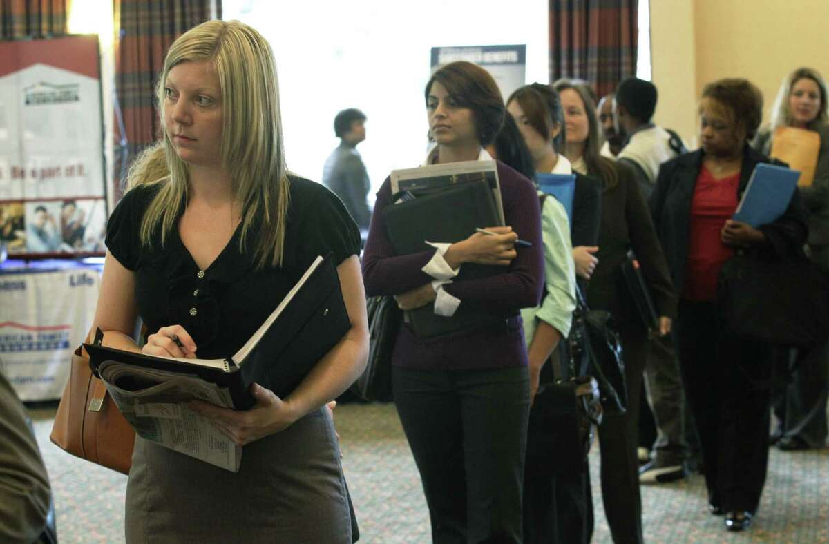 Annelie Ingvarsson, left, waits in line to talk to potential employers during a National Career Fairs job fair Wednesday in Bellevue, Wash. The number of people applying for unemployment benefits last week jumped to the highest level in three months, a sign that layoffs could be increasing. (AP Photo/Ted S. Warren)