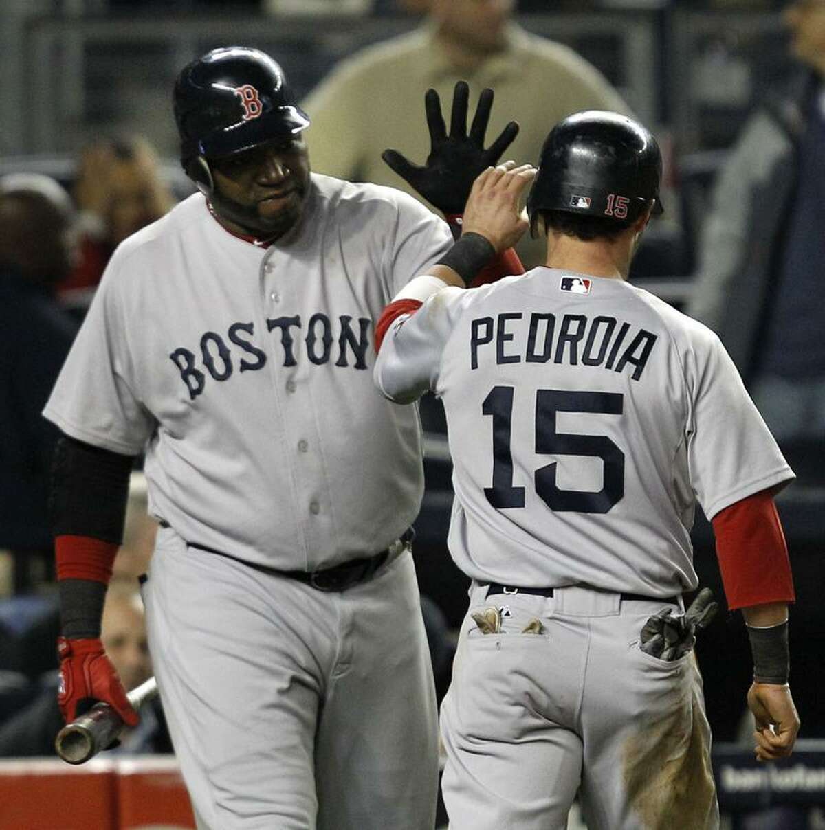 Boston Red Sox David Ortiz greets Dustin Pedroia (15) after Pedroia scored on Alex Rodriguez's seventh-inning error in their baseball game at Yankee Stadium Sunday, May 15, 2011 in New York. (AP Photo/Kathy Willens)