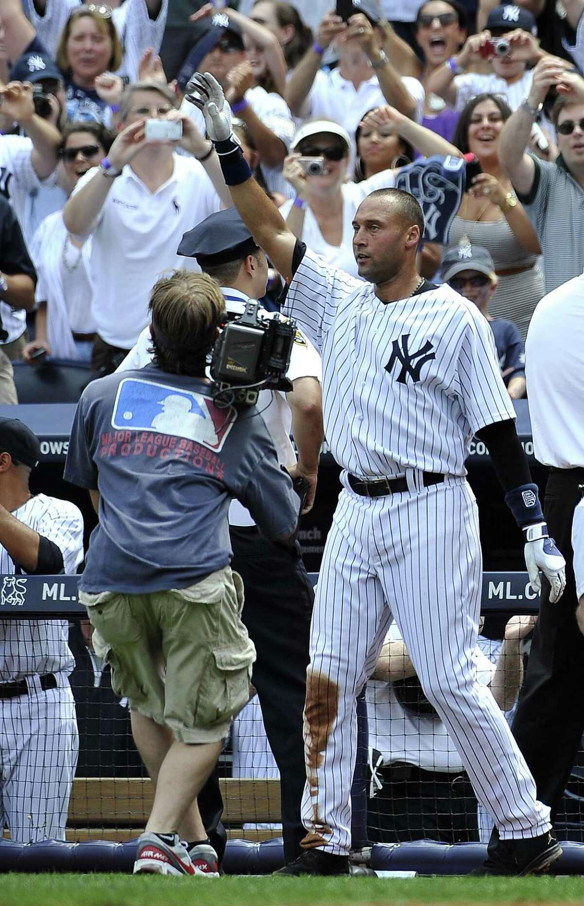 New York Yankees Derek Jeter waves to the cheers of the crowd after he hit a solo home run, for his 3,000th career hit off of Tampa Bay Rays starting pitcher David Price in the third inning of a baseball game on Saturday, July 9, 2011 at Yankee Stadium in New York. (AP Photo/Kathy Kmonicek)