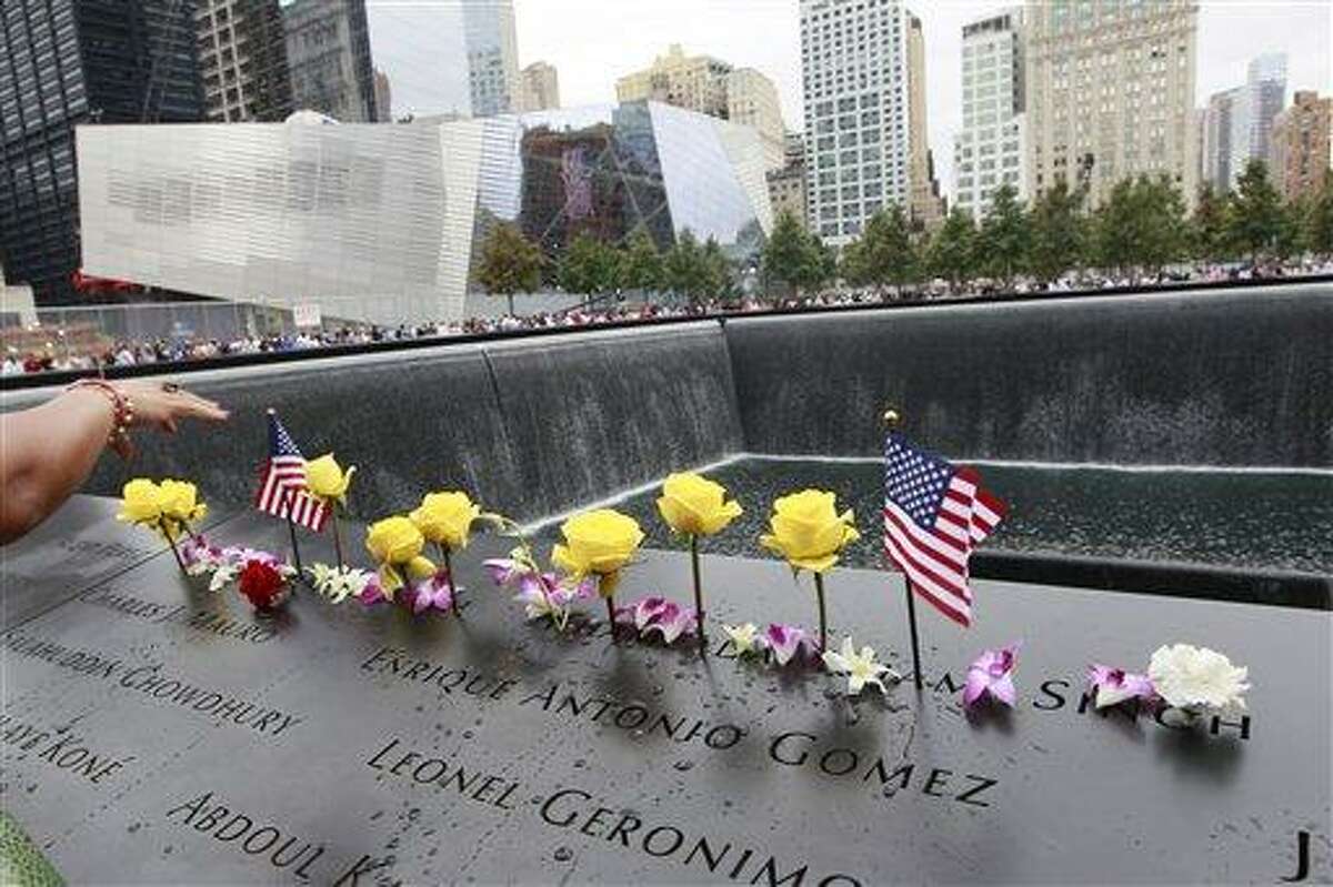 Flowers and American flags are arranged on the north pool of the National September 11 Memorial during a ceremony marking the 10th anniversary of the attacks at the World Trade Center, Sunday, Sept. 11, 2011 in New York. (AP Photo/Mary Altaffer)