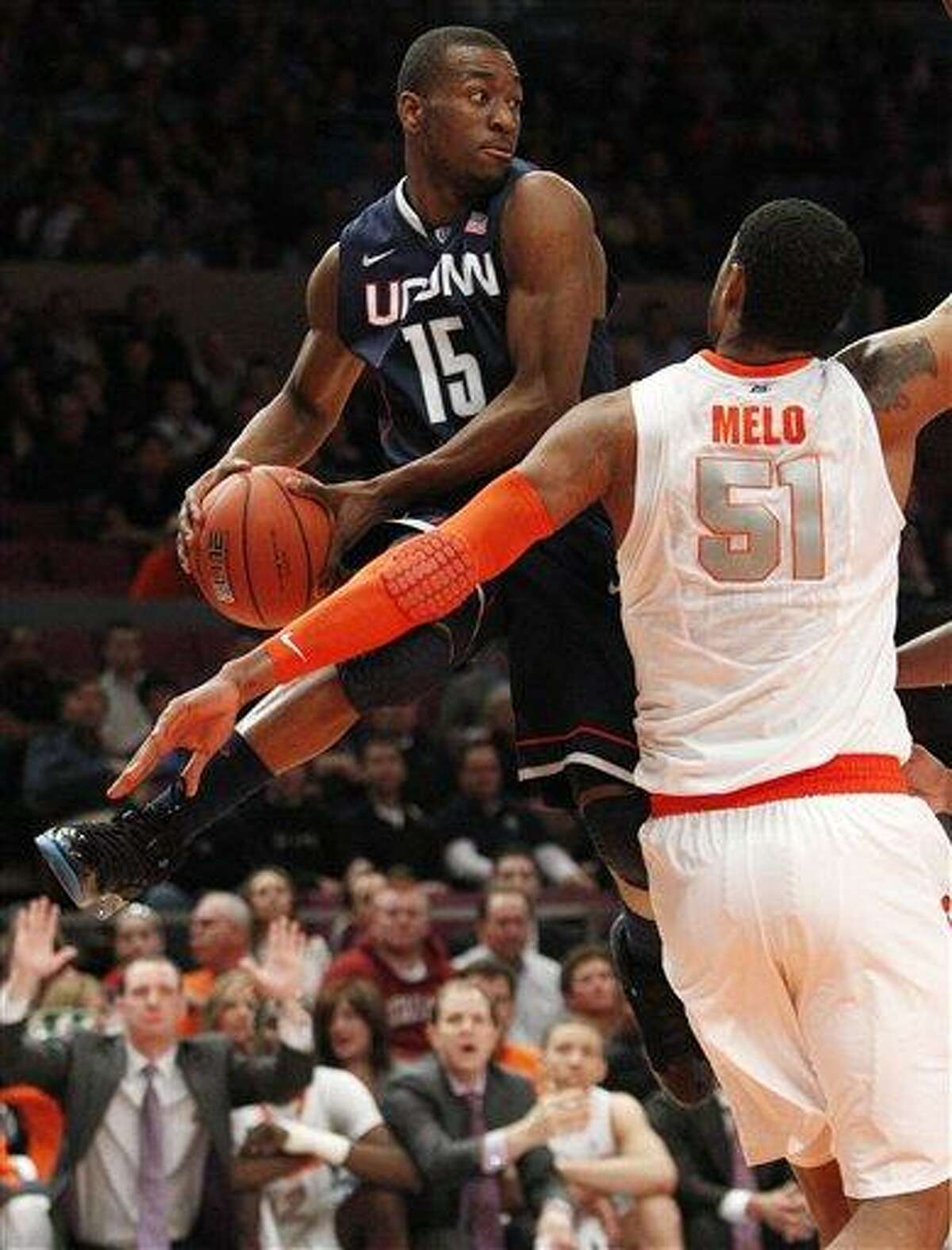 Connecticut's Kemba Walker (15) passes away from Syracuse's Fab Melo (51) during the first half of an NCAA college basketball game at the Big East Championship Friday, March 11, 2011, in New York. (AP Photo/Frank Franklin II)