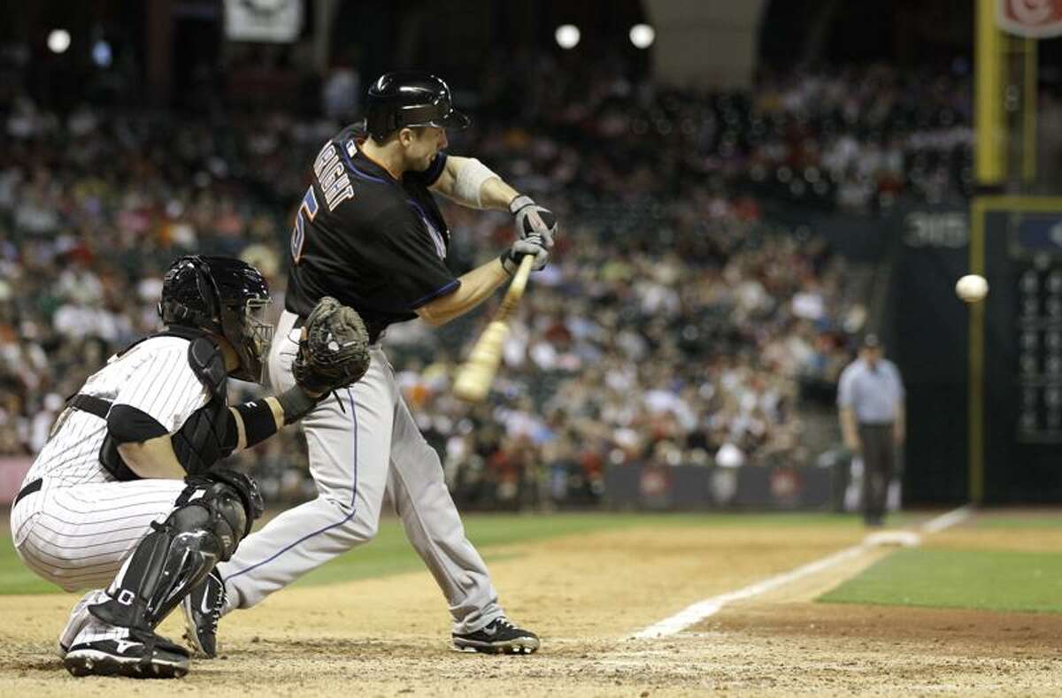 New York Mets' David Wright (5) hits a two-run home run as Houston Astros catcher Humberto Quintero, left, reaches for the pitch during the eighth inning of a baseball game Friday, May 13, 2011, in Houston. (AP Photo/David J. Phillip)
