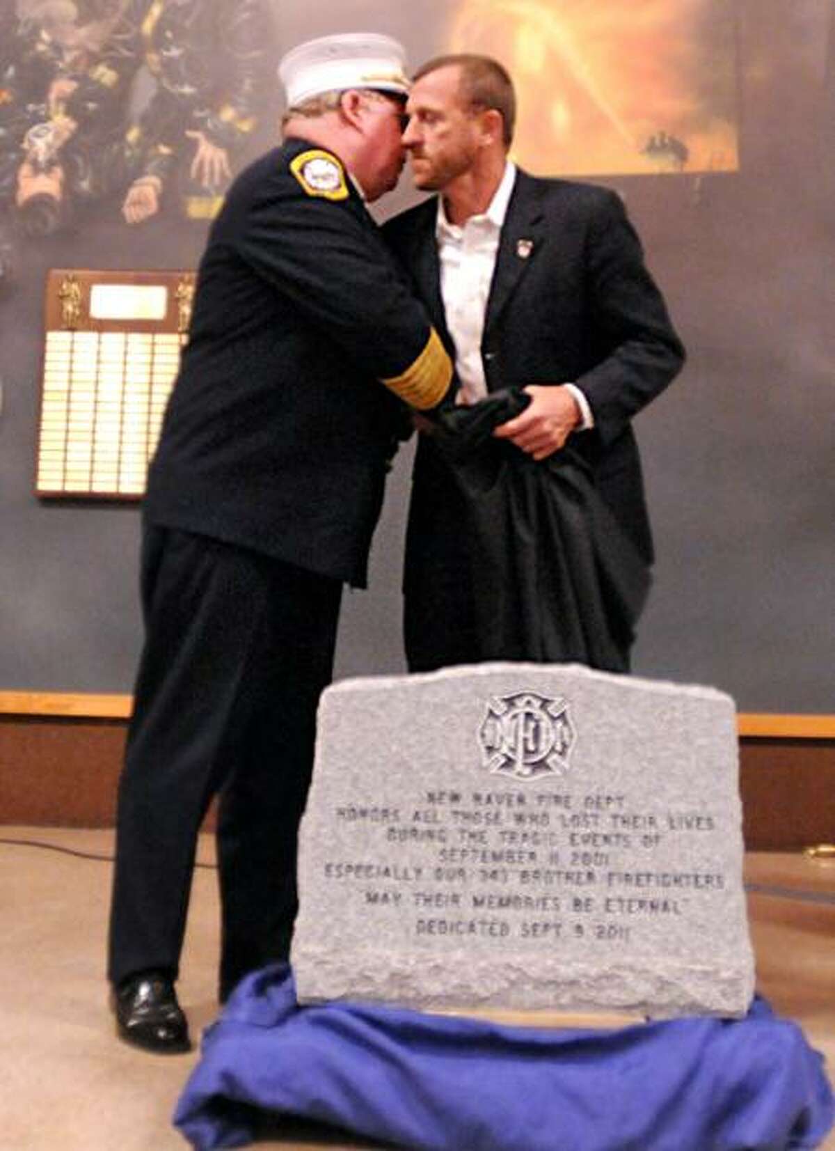 New Haven Fire Chief Michael E. Grant, left, hugs his friend, retired New York City Firefighter Tim Brown of Rescue Co. 3, after the unveiling Friday of a Memorial Stone honoring all the people who died in the World Trade Center attacks, including the firefighters who lost their lives. A memorial service was held Friday at the New Haven Regional Fire Training Academy to commemorate the 10th anniversary of the attacks. Brown was a first responder to the World Trade Center. Peter Hvizdak/Register September 9, 2011 ph2360 Connecticut