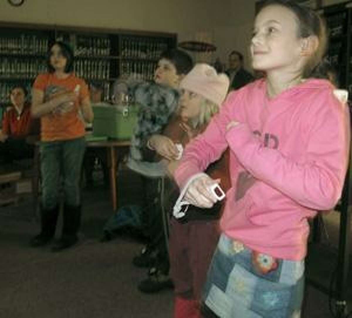 Photo by JOHN HAEGER Morgan Carroll, 8, of Oneida, plays the Wii at the Oneida Piblic Library on Monday, Jan. 10, 2011. The library's Wii multi-generational games program is offered monthly to bring together children savvy in the latest technology together with their older relatives who may need extra coaching.