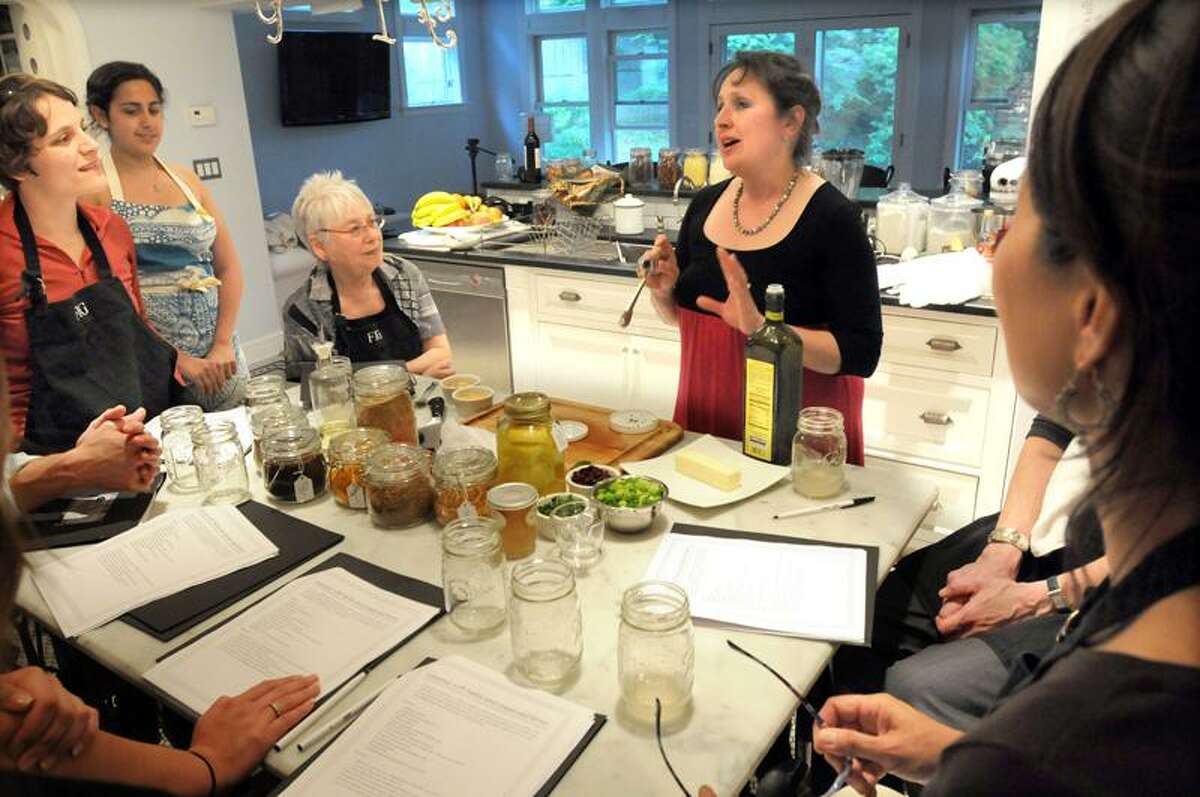 Heide Lang leads a Fig Cooking School class at her home in Hamden with students Lauren Tagliatela of North Haven left, Jane Lederer of New Haven, seated, and Kai Friedman of Bethany, right. Lang's daughter and assistant Gabrielle Siegel is second from left.