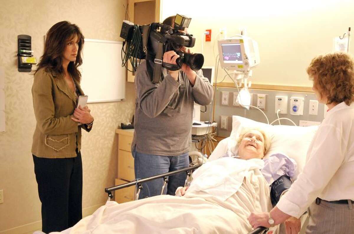 Cusato and a News 8 videographer listen as registered nurse Paula Novak discusses "healing touch" with Marie Bontempo of Norwich, who is not a dementia patient, at Backus Hospital in Norwich. Cusato's four-part series on Alzheimer's disease and dementia will air from 5-8 a.m. Tuesdays in May. (Jeff Evans/Backus Hospital)