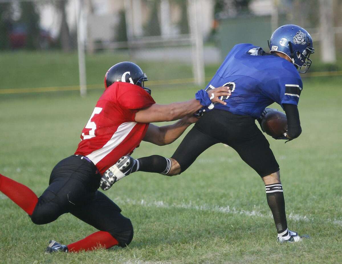 Dispatch Staff Photo by JOHN HAEGERUtica Yard Dogs Calvin Lang (30) battles his way in to the endzone for the touchdown on the blocked punt as Cortlands Joe Johnson (25) tries to make the tackle in the third quarter of the game in Oneida on Saturday Aug. 20, 2011.