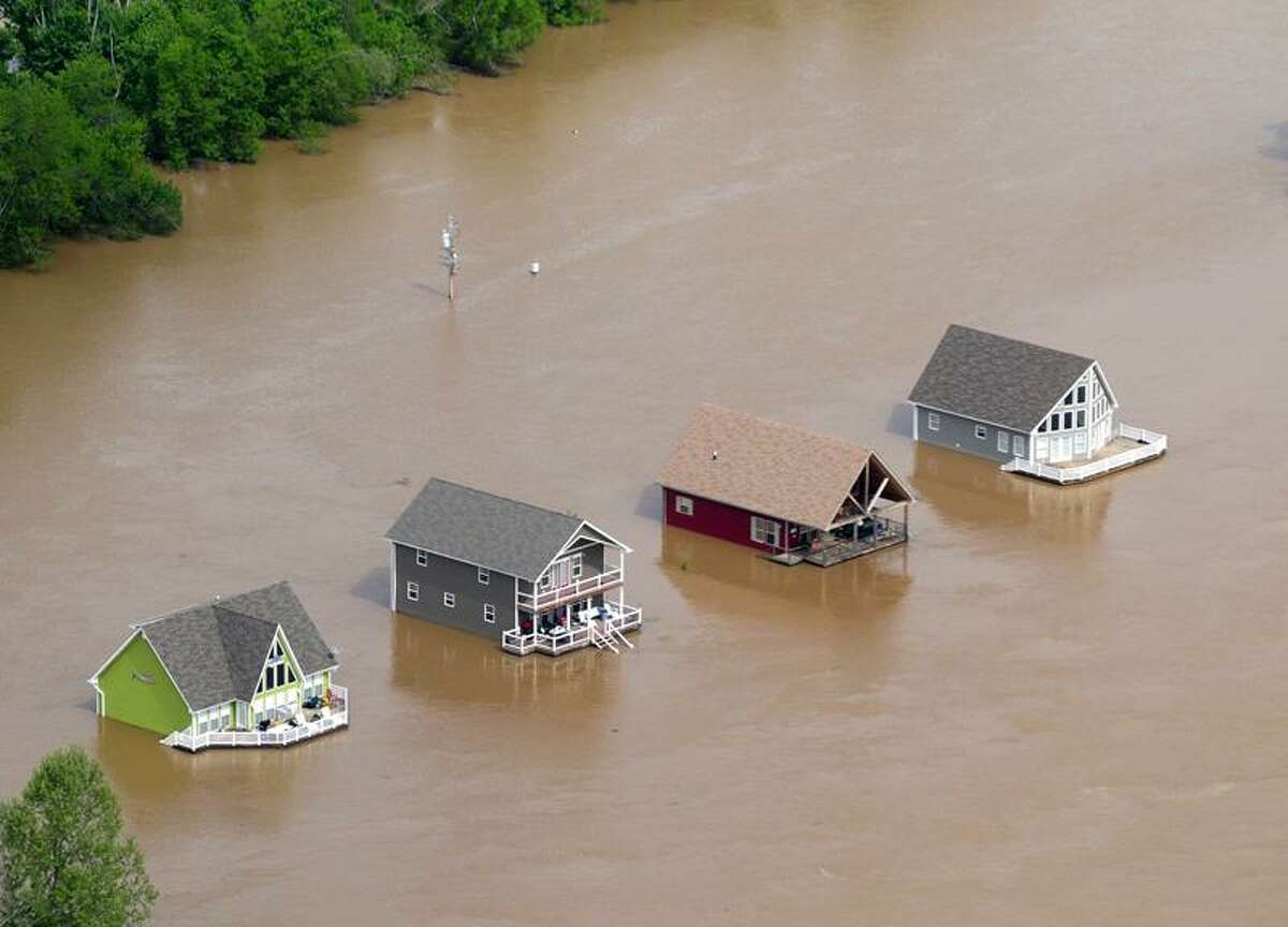 Four houses are surrounded by floodwaters from the Current River just outside Doniphan, Mo., Tuesday. Associated Press