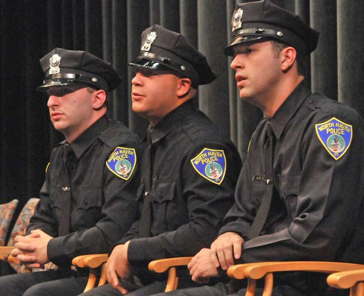 Former New Haven police officers Michael DiCocco, Maurice Martin and John Gaspar III, prepare to be sworn in as North Haven police officers at Tuesday night's ceremony at North Haven High School. The officers were laid off from New Haven's police department. (Brad Horrigan/Register)