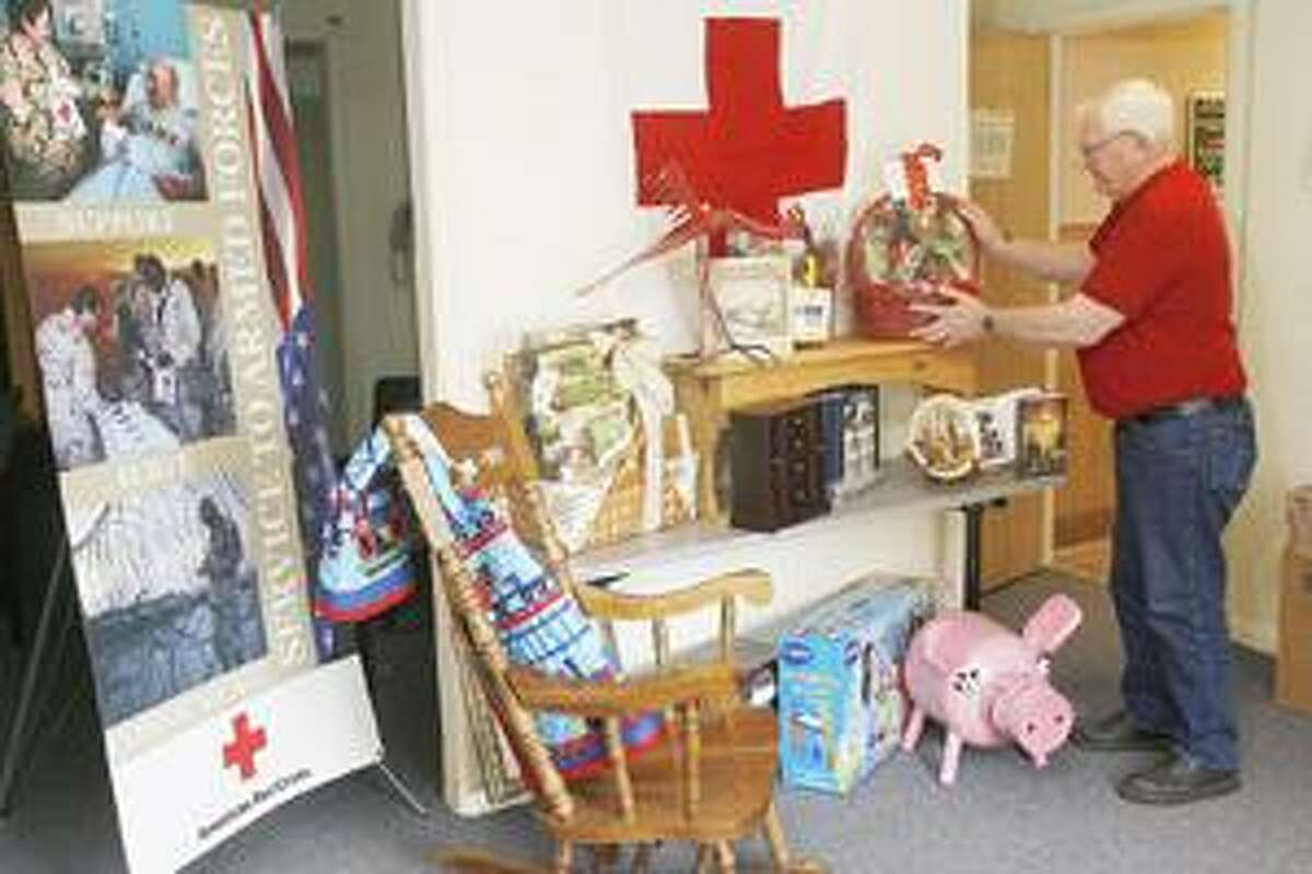 Photo by JOHN HAEGER Carl Carlstead readies items for the annual Madison Oneida Chapter of the American Red Cross' Silent Auction on Friday, April 22, 2011. The auction will be Friday, April 29, 2011.