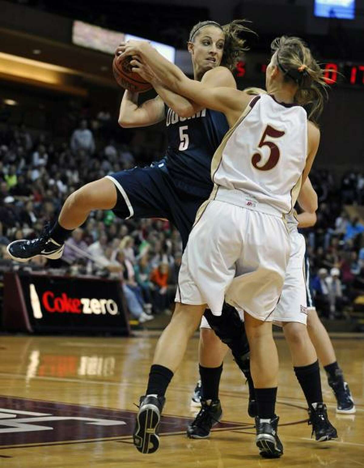 Connecticut's Caroline Doty, left, looks to pass as College of Charleston's Cathryn Hardy defends during the first half of an NCAA college basketball game on Wednesday, Dec. 21, 2011, in Charleston, S.C. (AP Photo/Rainier Ehrhardt)