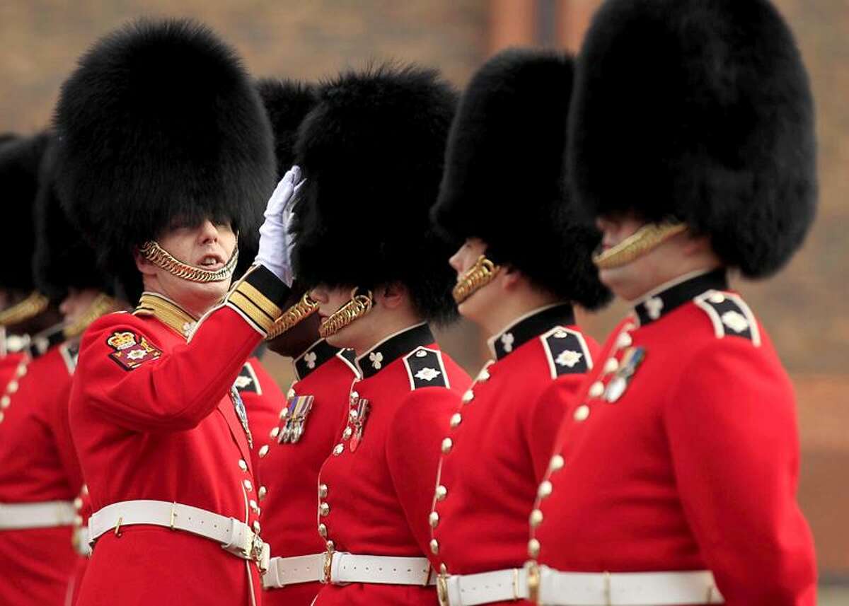 A Company Sergeant Major of the 1st Battalion Irish Guards inspects guardsmen's bearskins, as they take part in an inspection ahead of the royal wedding at their barracks in Windsor, England, Thursday, April 21, 2011. Britain's Prince William is due to marry Kate Middleton on April 29. (AP Photo/Matt Dunham)