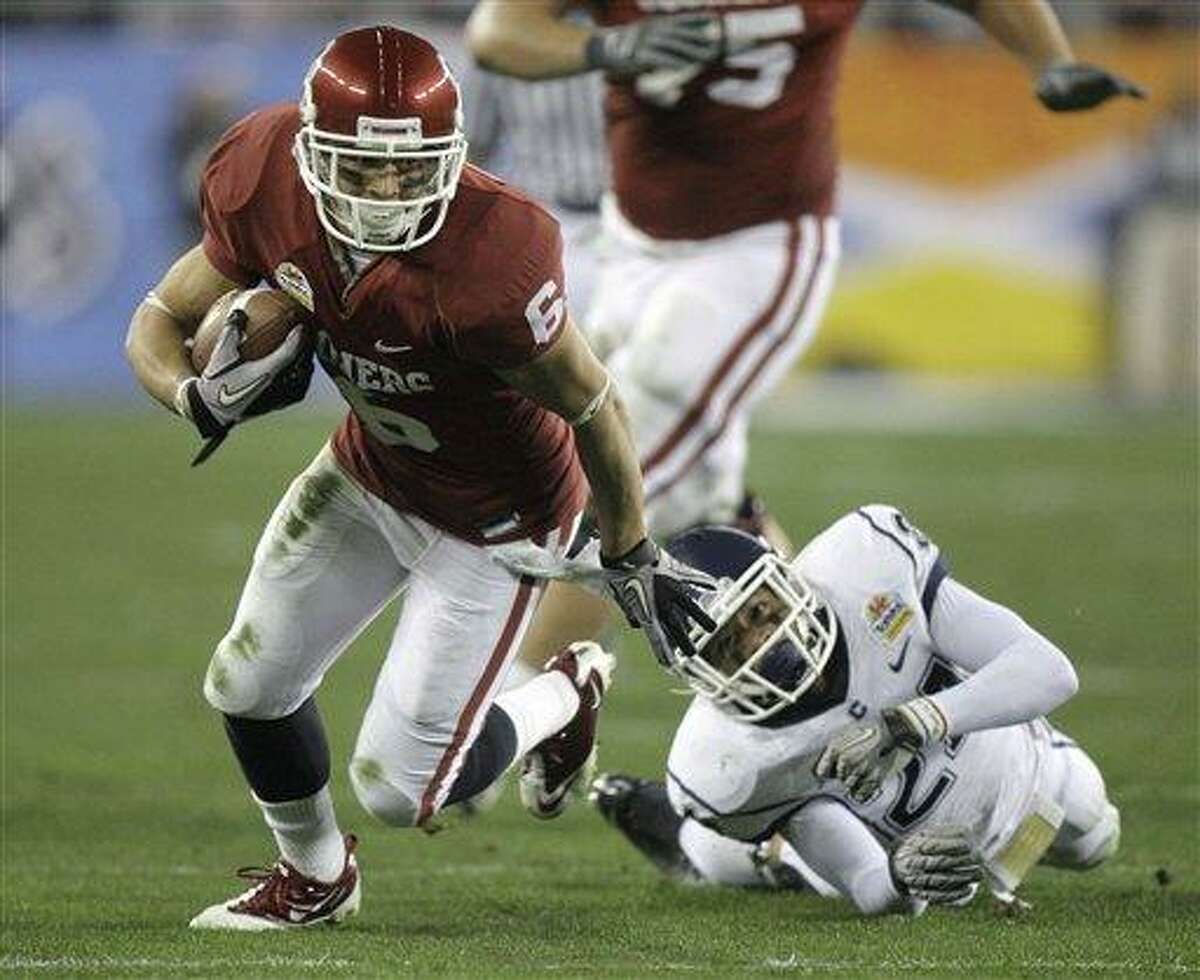 Oklahoma Sooners wide receiver Cameron Kenney (6) slips past the reach of Connecticut cornerback Dwayne Gratz (24) during the third quarter of the Fiesta Bowl NCAA college football game Saturday, Jan. 1, 2011, in Glendale, Ariz. (AP Photo/Paul Connors)
