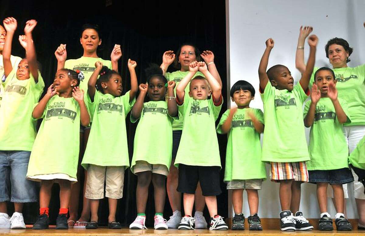 Children from Sleeping Giant Day Care sing "The Wheels on the Bus" during the unveiling of the a new hydrogen-powered bus at Miller Library in Hamden Tuesday. Peter Casolino/Register