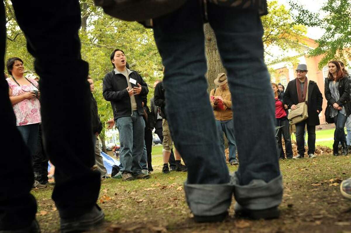 Jennifer Lopez of New Haven, left, and Andrew Jeon of New Haven of the Occupy New Haven Media Group Committee, second from left, participate in the Occupy New Haven general assembly meeting Sunday afternoon on the Upper Green. The assemblies are when Occupy New Haven activists air proposals and vote on them. Photo by Peter Hvizdak / New Haven Register