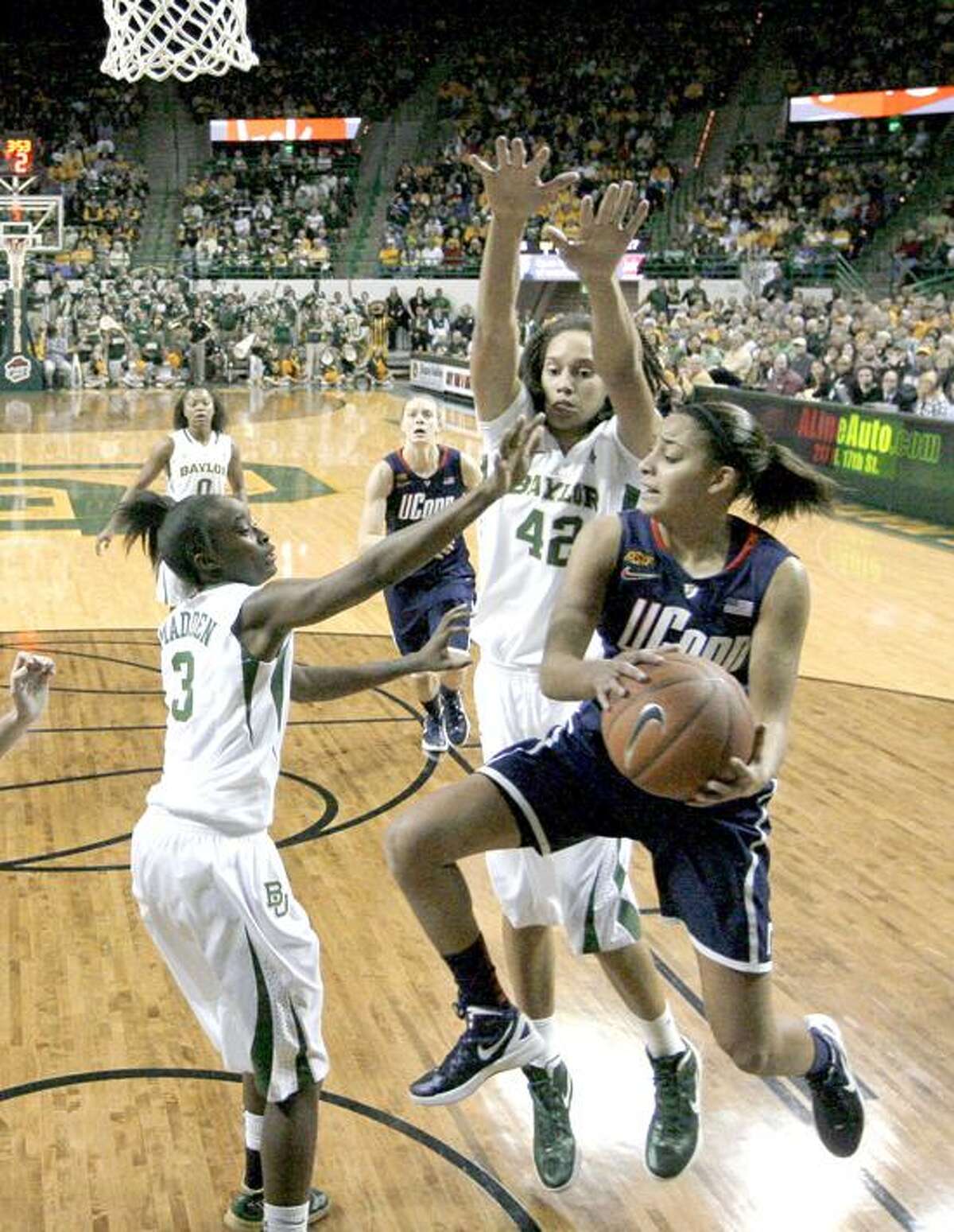 Baylor guard Jordan Madden (3) and Brittney Griner (42) combine to stop a drive to the basket by Connecticut guard Bria Hartley, front, in the first half of an NCAA college basketball game Sunday, Dec. 18, 2011, in Waco, Texas. (AP Photo/Tony Gutierrez)