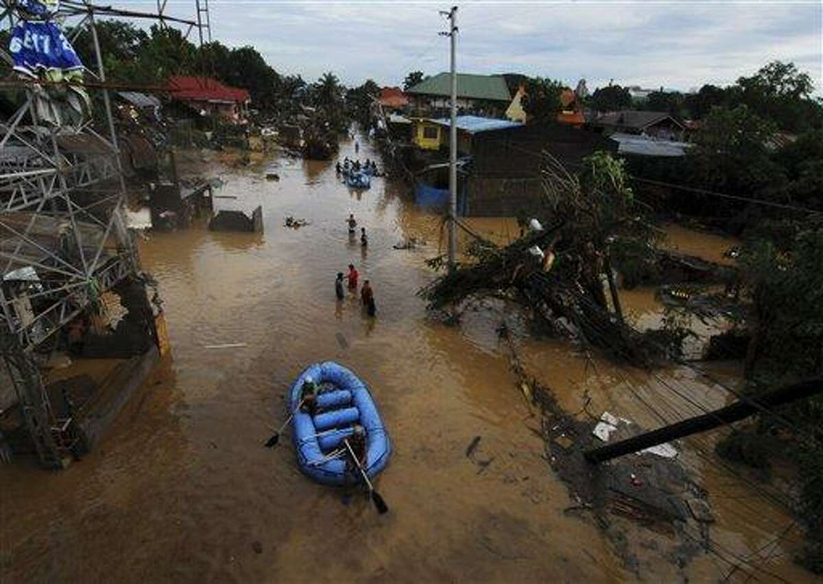 Rescuers paddle their rubber boat to search for survivors following a flash flood that inundated Cagayan de Oro city, Philippines, Saturday, Dec. 17, 2011. A tropical storm triggered flash floods in the southern Philippines, killing scores of people and missing more. Mayor Lawrence Cruz of nearby Iligan said the coast guard and other rescuers were scouring the waters off his coastal city for survivors or bodies that may have been swept to the sea by a swollen river. (AP Photo/Froilan Gallardo)