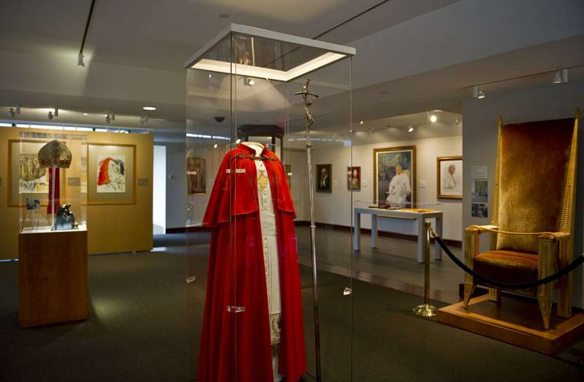 This shot of the exhibit shows the case with a cassock and red cape and the Kevin Roche-designed chair.