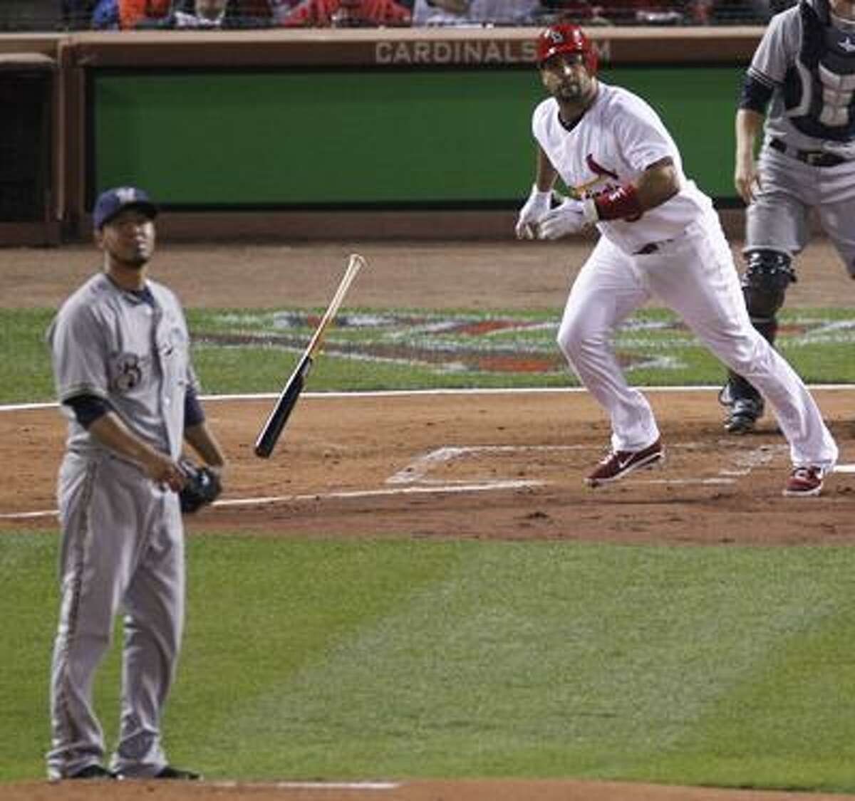 Milwaukee Brewers starting pitcher Yovani Gallardo and St. Louis Cardinals' Albert Pujols watch Pujols' RBI double during the first inning of Game 3 of baseball's National League championship series Wednesday, Oct. 12, 2011, in St. Louis. (AP Photo/Jeff Roberson)