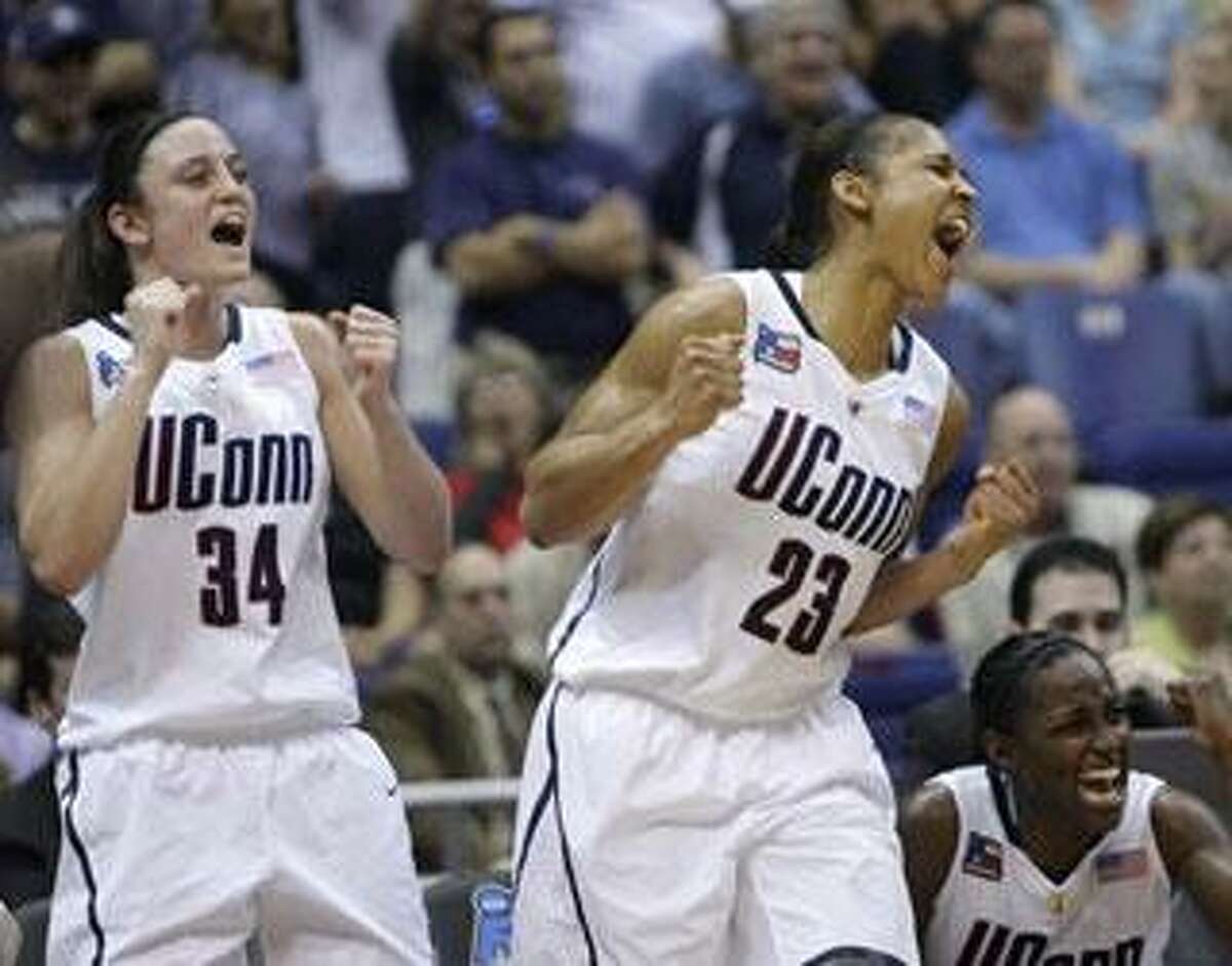 Connecticut's Kelly Faris (34), Maya Moore (23) and Kalana Greene, bottom right, celebrate in the closing seconds of Connecticut's 70-50 win over Baylor in a semifinal in the Final Four of the NCAA women's college basketball tournament Sunday, April 4, 2010, in San Antonio. Connecticut faces Stanford on Tuesday for the title. (AP Photo/Sue Ogrocki)