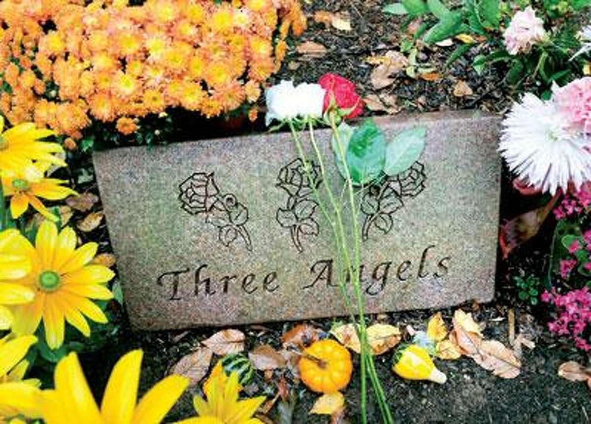 Three roses, one red and two white, symbolize Dr. William Petit Jr.'s wife, Jennifer Hawke-Petit, and two daughters, Michaela and Hayley. The marker is in a commemorative garden on the site of the former Petit home in Cheshire. (Arnold Gold/Register)