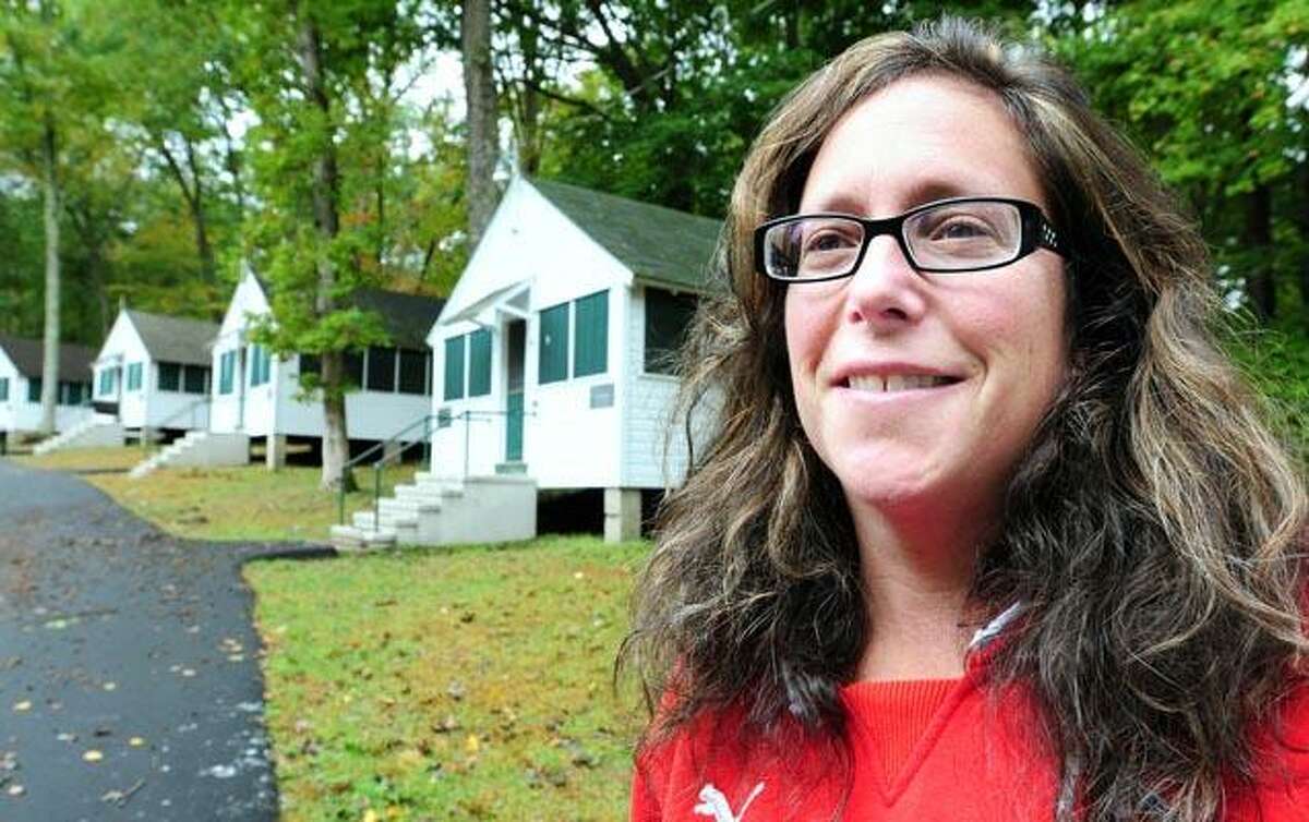 Ruth Ann Ornstein, executive director of Camp Laurelwood in Madison, stands in front of the renovated boys' campus cabins. (Arnold Gold/Register photos)