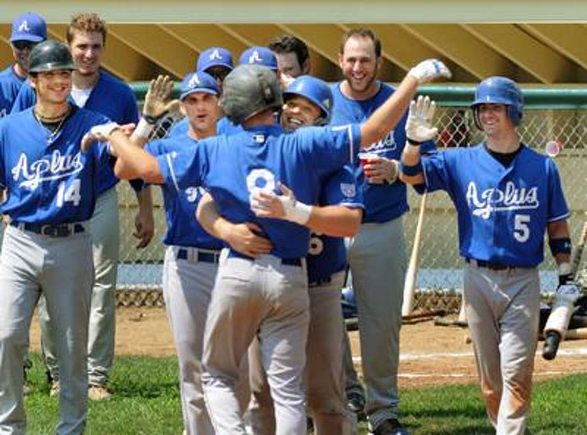 Matt Denofria (#8), of APlus, is welcomed across the plate after his two run home run in the 7th inning of the Twilght League Championship game against Stamford. (Melanie Stengel/Register)