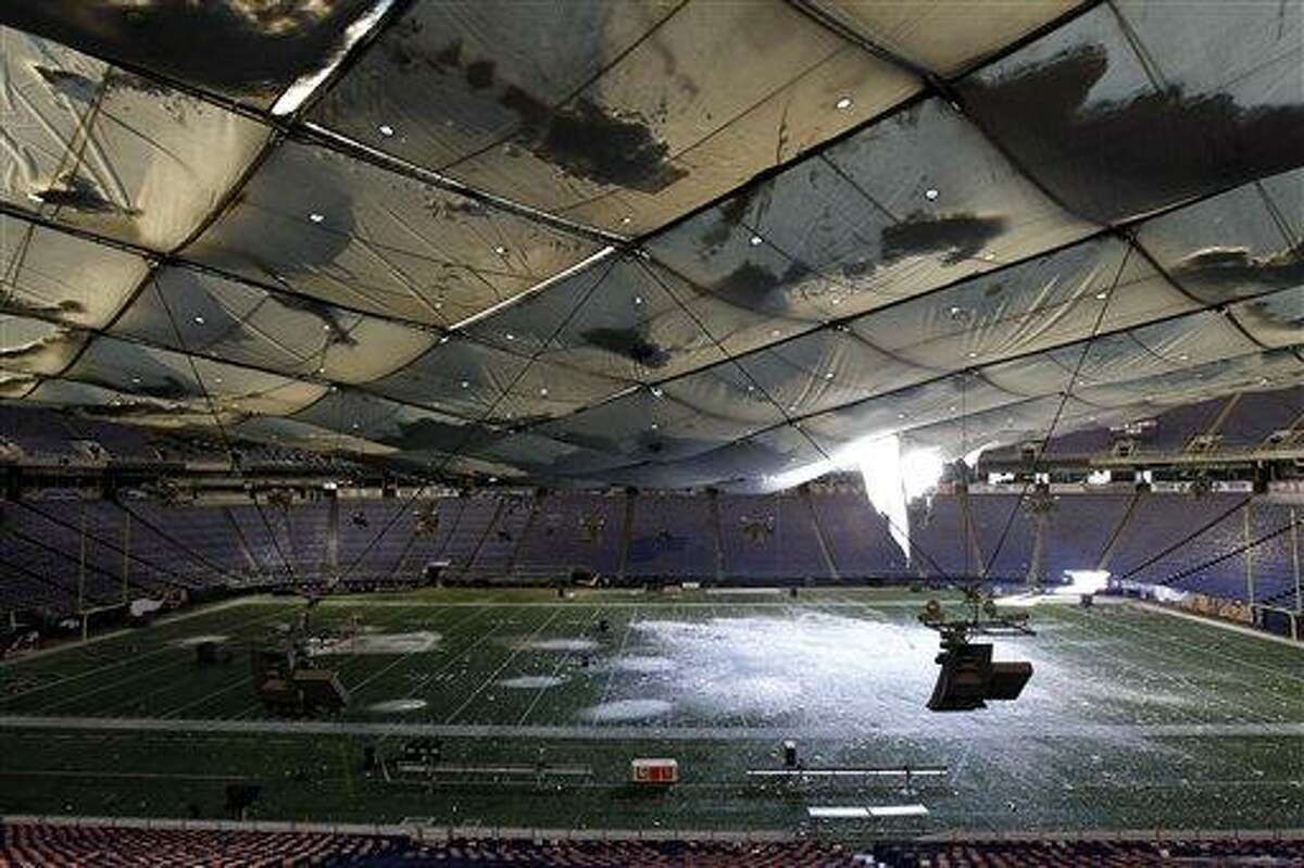 Snow falls into the field from a hole in the collapsed roof of the Metrodome in Minneapolis Sunday, Dec. 12, 2010. The inflatable roof of the Metrodome collapsed Sunday after a snowstorm that dumped 17 inches (43 cms) on Minneapolis. No one was hurt, but the roof failure sent the NFL scrambling to find a new venue for the Vikings' game against the New York Giants. (AP Photo/Ann Heisenfelt)
