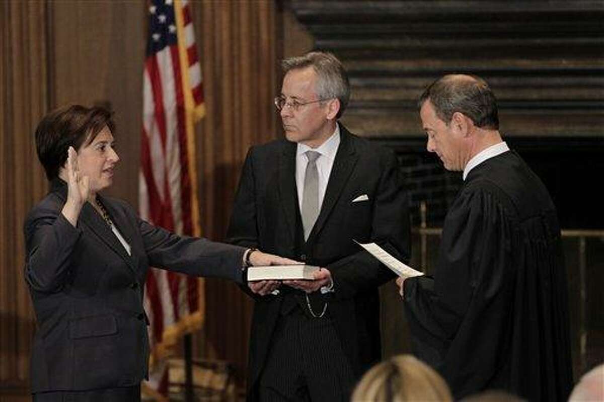 Elena Kagan is sworn in as the Supreme Court's newest member as Chief Justice John Roberts, right, administers the judicial oath, at the Supreme Court Building in Washington, Saturday, Aug. 7, 2010. The Bible is held by Jeffrey Minear, center, counselor to the chief justice. Kagan, 50, who replaces retired Justice John Paul Stevens, becomes the fourth woman to sit on the high court, and is the first Supreme Court justice in nearly four decades with no previous experience as a judge. (AP Photo/J. Scott Applewhite)