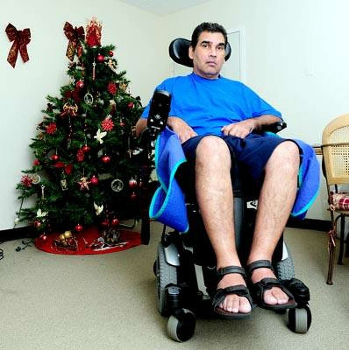 Gilberto Cosme, a victim of Lou Gehrig's disease, sits in the living room of his home on George Street in New Haven Thursday. Thieves stole his handicapped accessible van. (Arnold Gold/Register)