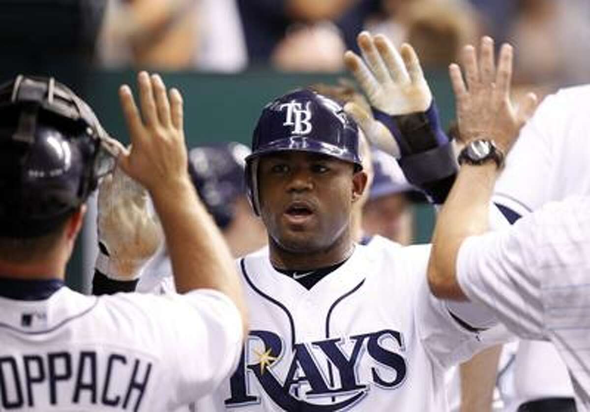FILE - This July 27, 2010, file photo shows Tampa Bay Rays' Carl Crawford being congratulated after scoring in the sixth inning of the Rays' 3-2 victory over the Detroit Tigers in a baseball game in St. Petersburg, Fla. Crawford has reached a preliminary agreement with the Boston Red Sox on a $142 million, seven-year contract, a person familiar with the negotiations told The Associated Press. The agreement is subject to Crawford passing a physical, the person said Wednesday night, Dec. 8, 2010.(AP Photo/Mike Carlson, File)