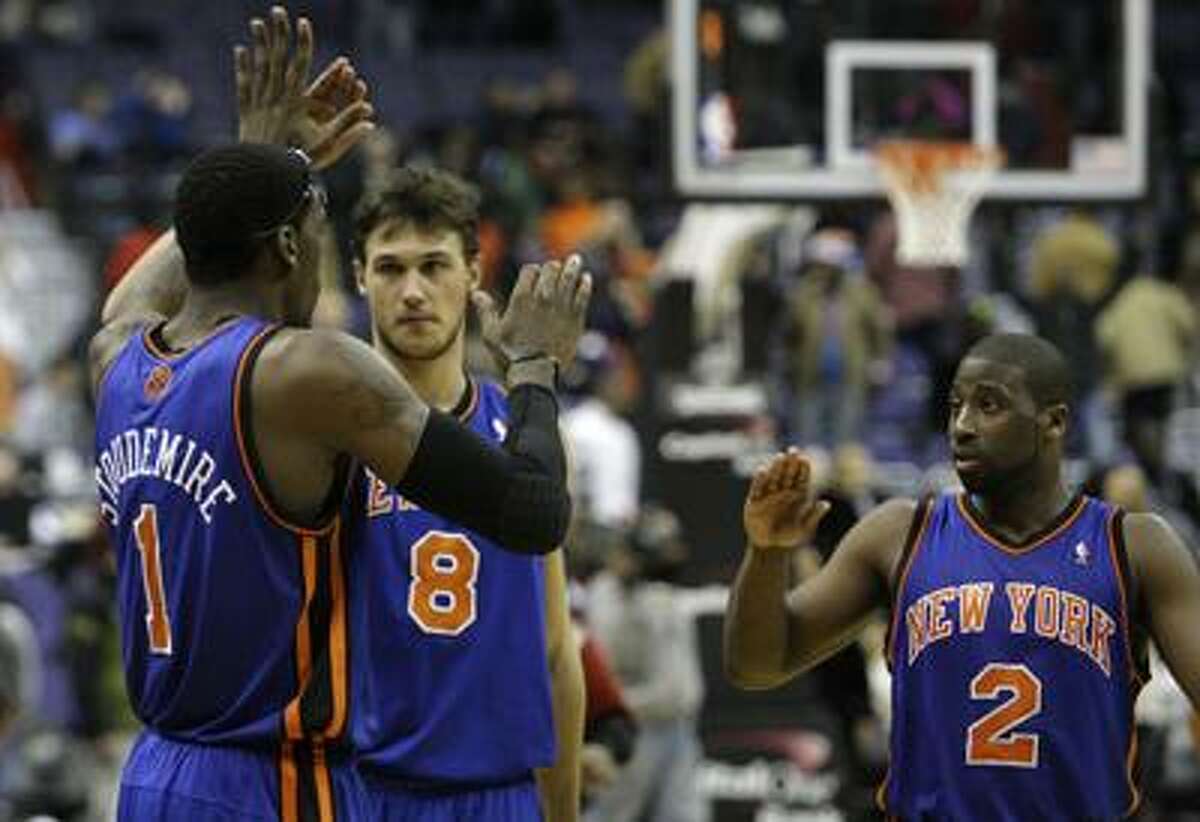 New York Knicks teammates Amare Stoudemire (1), Danilo Gallinari (8), and Raymond Felton (2) congratulate each other on their win against the Washington Wizards at an NBA basketball game at the Verizon Center in Washington on Friday, Dec. 10, 2010. The Knicks won 101-95, in their longest winning streak in nearly a decade. (AP Photo/Jacquelyn Martin)