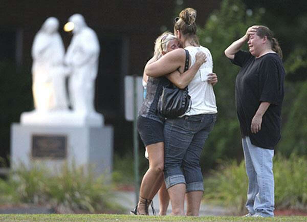 Mourners embrace at a memorial service Wednesday evening at St. Margaret Mary Church in South Windsor. (Associated Press)