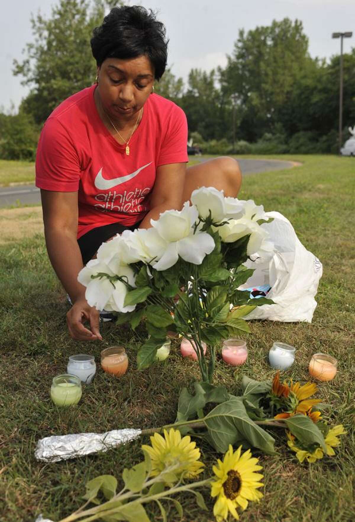 Terrie Thomas, of South Windsor, lights a candle for each victim killed outside of Hartford Distributors in Manchester, Conn., Wednesday, Aug. 4, 2010. Omar S. Thornton, a driver for Hartford Distributors, killed eight people, plus himself at the beer distribution company in Connecticut on Tuesday morning. (AP Photo/Jessica Hill)