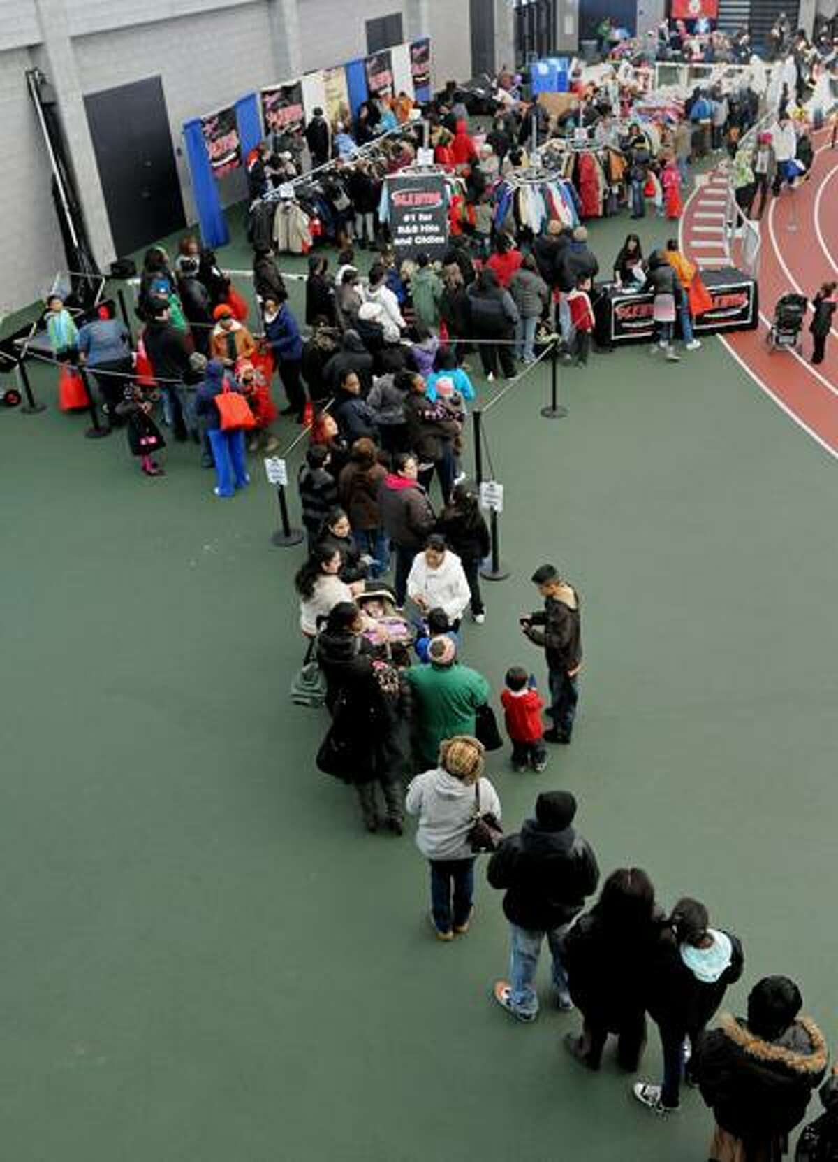 New Haven--A line of hundreds of New Haven community members extends from the out in the hallway into the New Haven fieldhouse at Sunday's winter coat distribution. Photo by Brad Horrigan/New Haven Register-12/05/10.