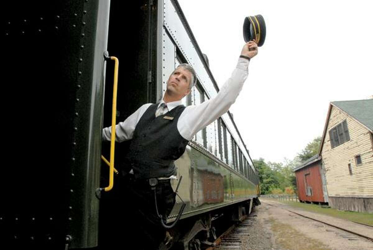 Rob Bradway, conductor and defacto maitre d' of the Valley Railroad's Essex Clipper Dinner Train ride, signals that the train can start its journey along the shoreline. The train mimics the romance, intimacy and adventure of fine dining in a 1920s-style Pullman dinner train car.